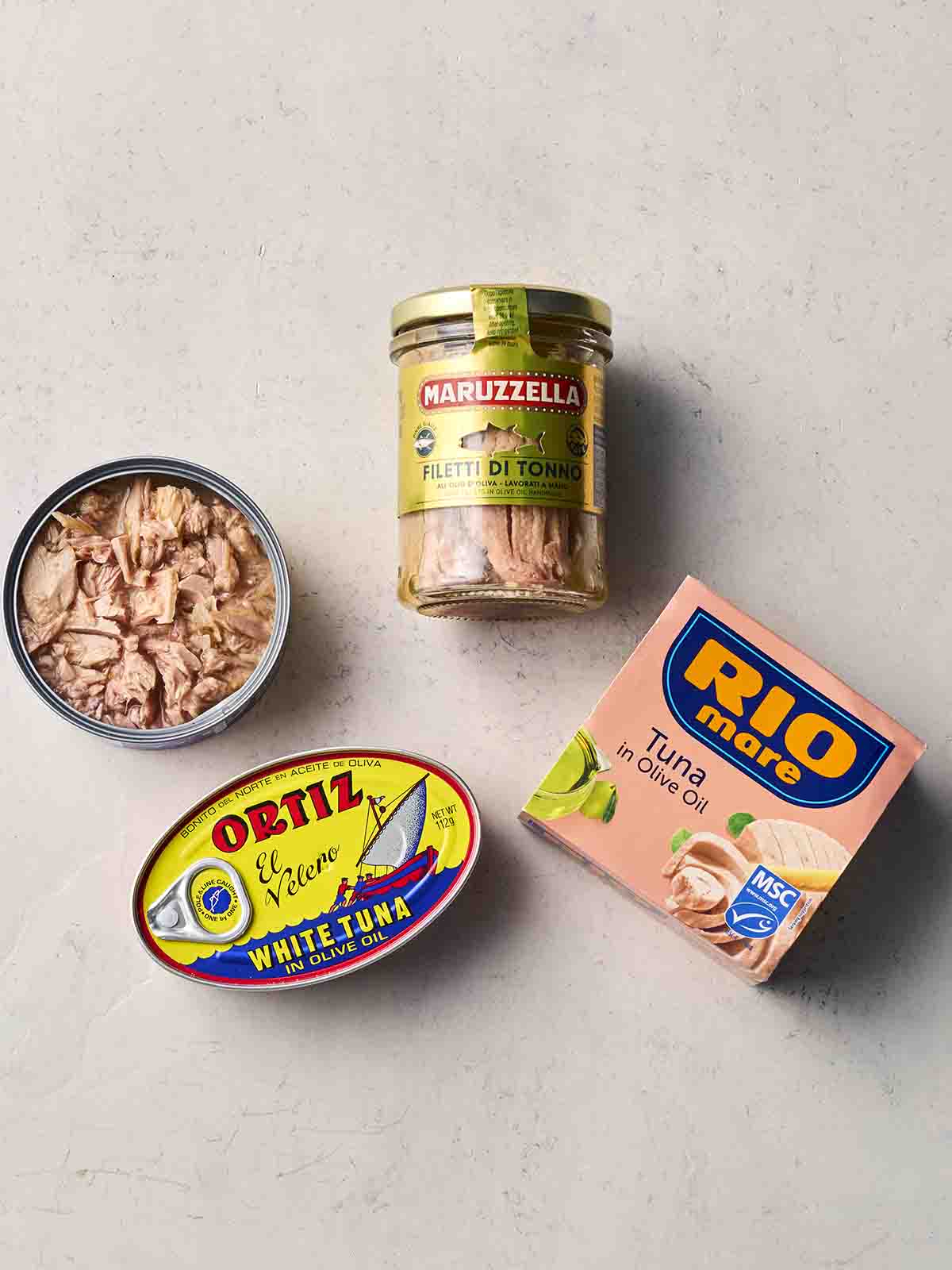 Four different tunas on a white surface.