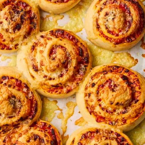 Freshly baked Pizza Swirls straight out of the oven, with melted cheese on top.