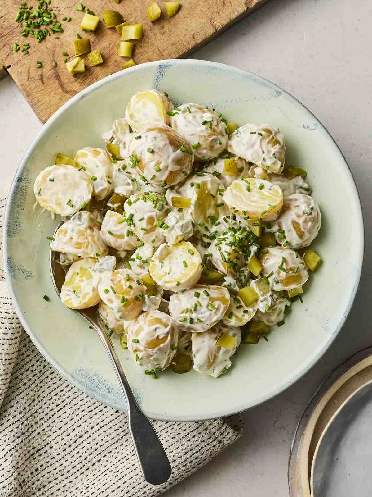 A homemade potato salad in a bowl with a spoon, ready to serve.