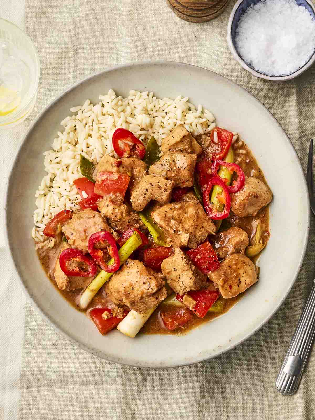 A dinner plate with a cooked meal of Salt and Pepper Chinese Chicken and rice on.