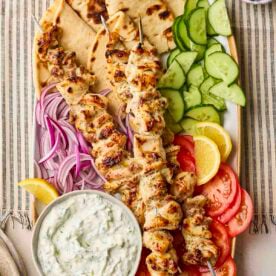 A platter of chicken souvlaki to share with flatbreads, salad and tzatziki.