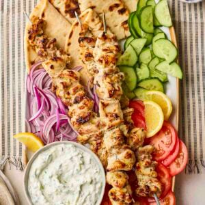 A platter of chicken souvlaki to share with flatbreads, salad and tzatziki.