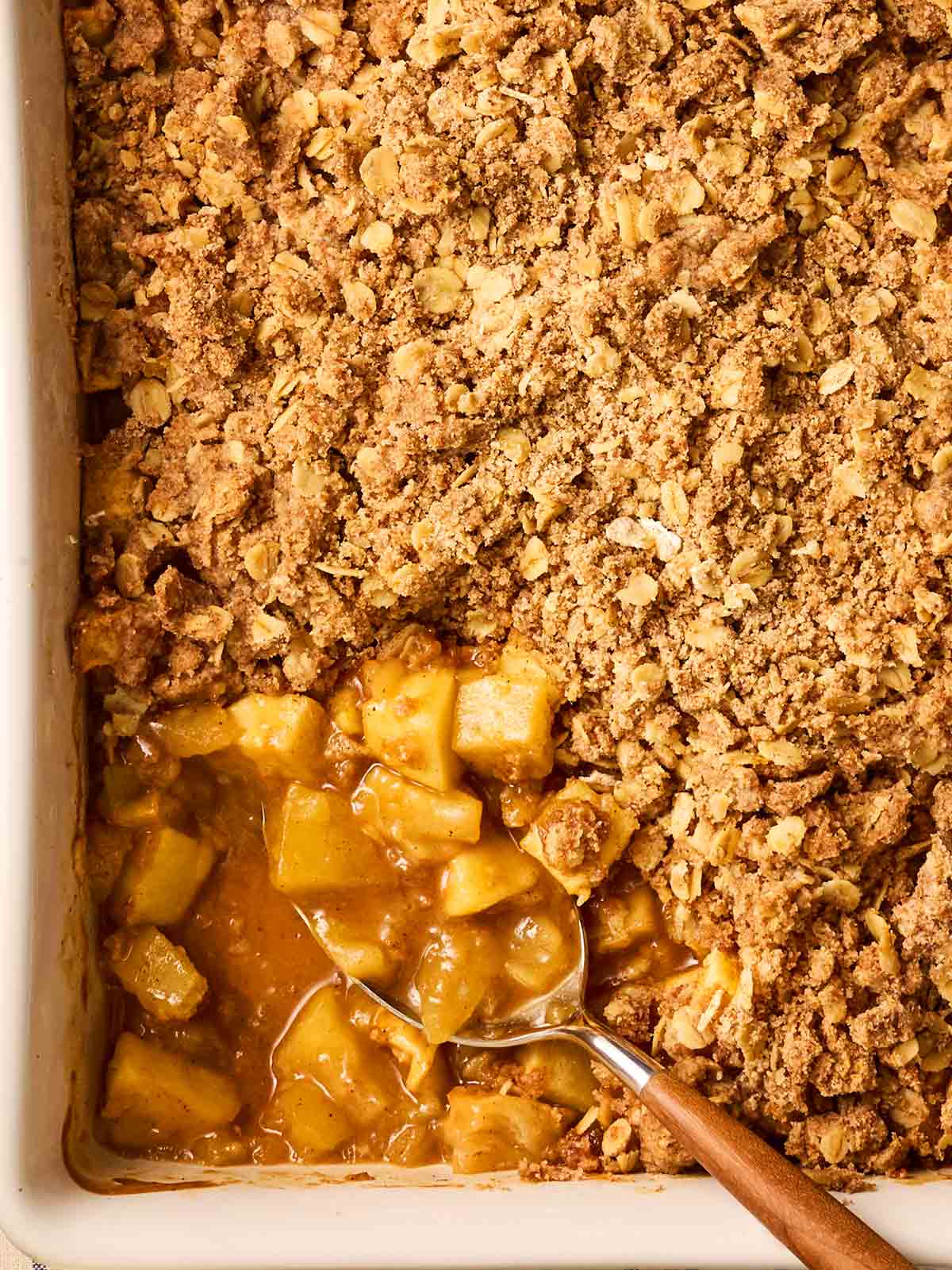 A classic Apple Crumble being served up with a spoon.