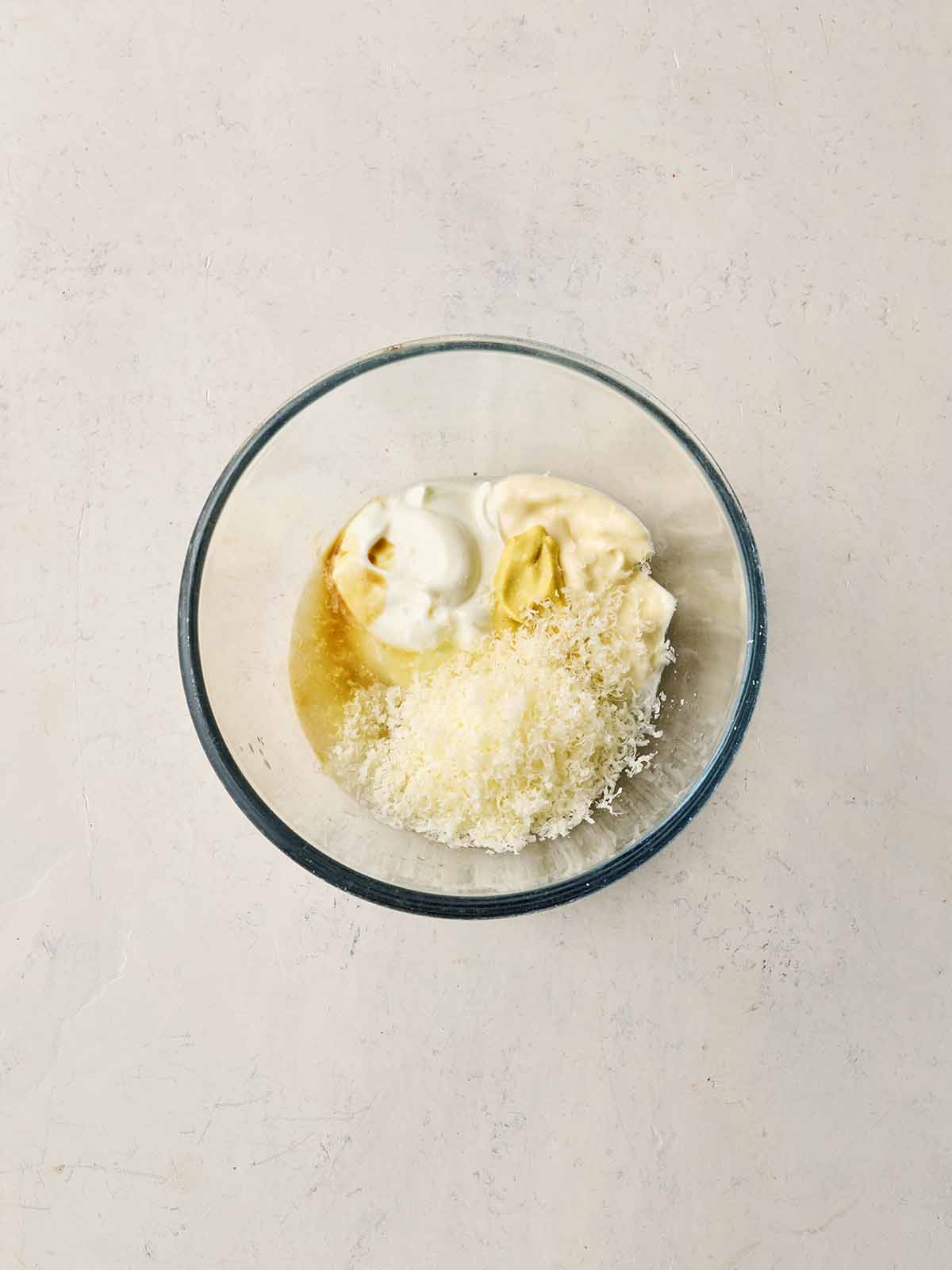 A bowl of caesar dressing ingredients, not yet mixed together.