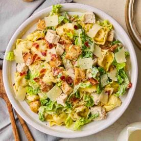 A white plate filled with Chicken Caesar Pasta Salad.