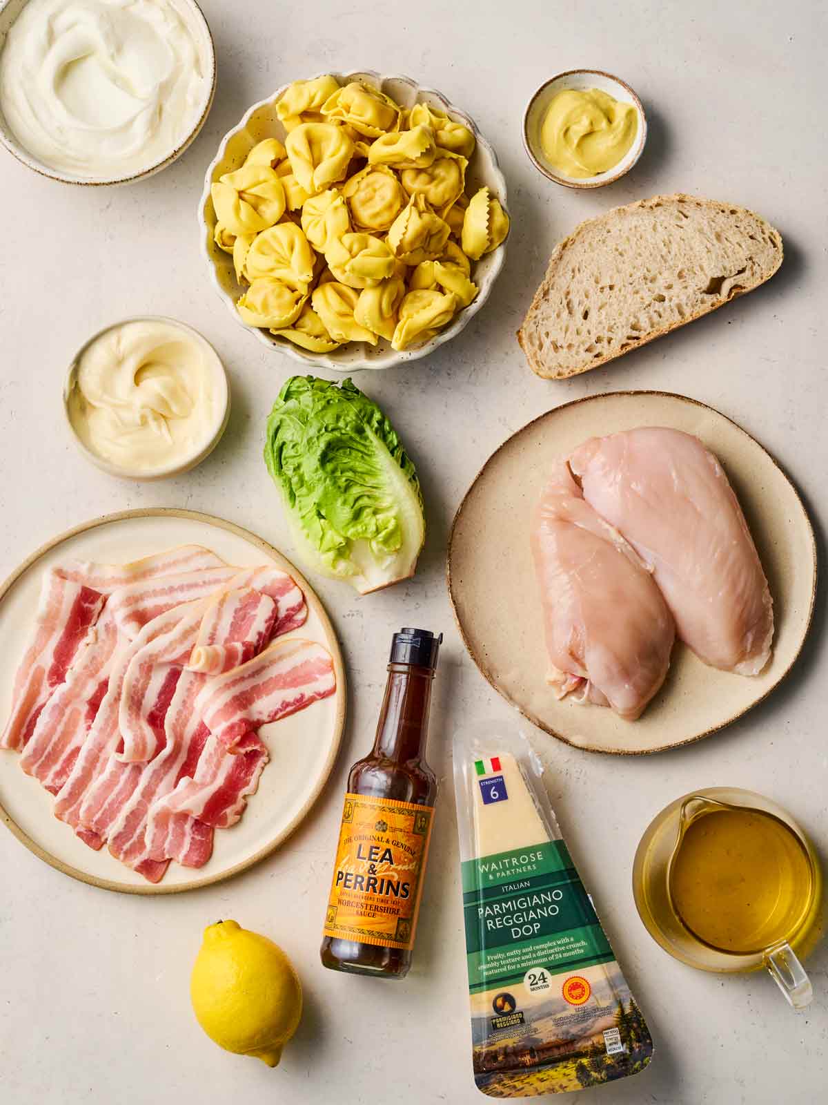 Ingredients for making a Chicken Caesar Salad Pasta on a white counter.