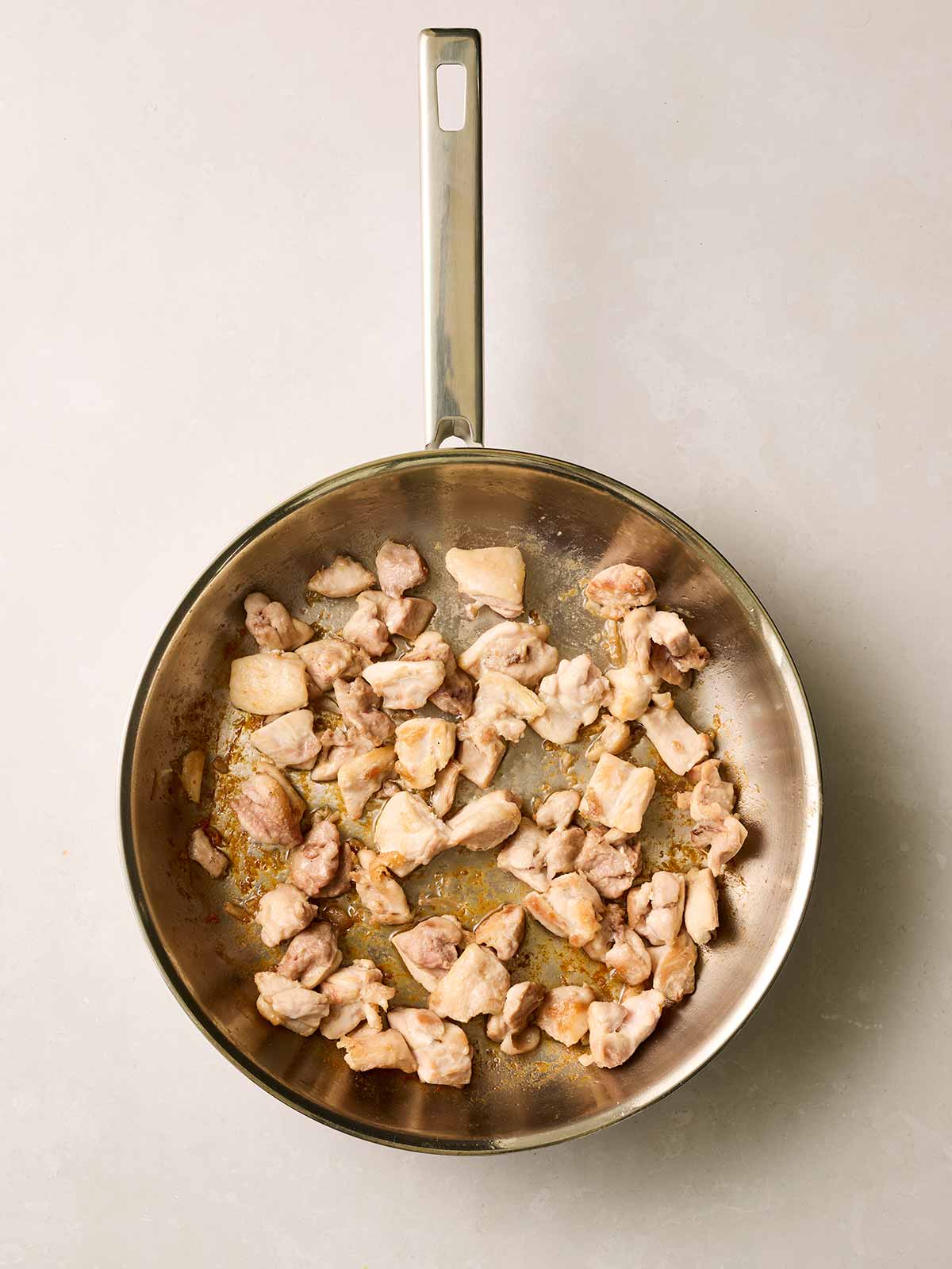 A pan with cooking chicken inside.