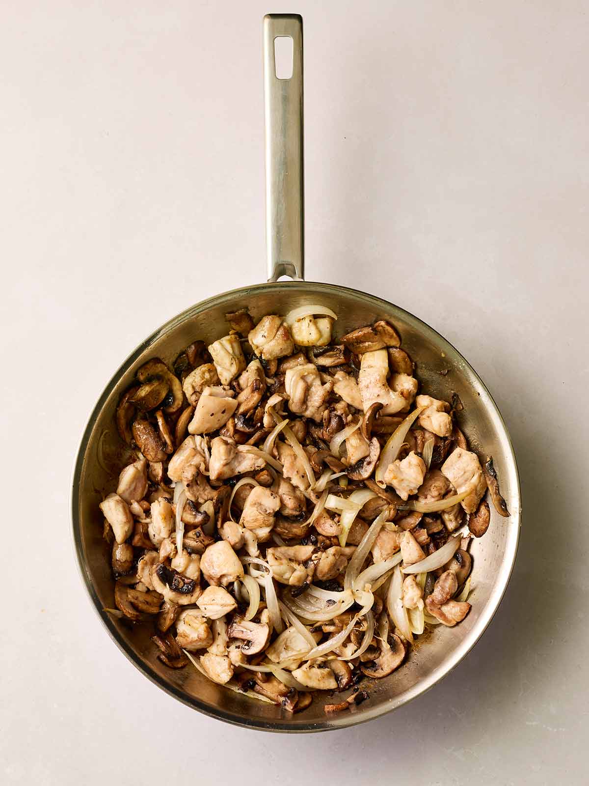 A pan filled with cooking mushrooms.