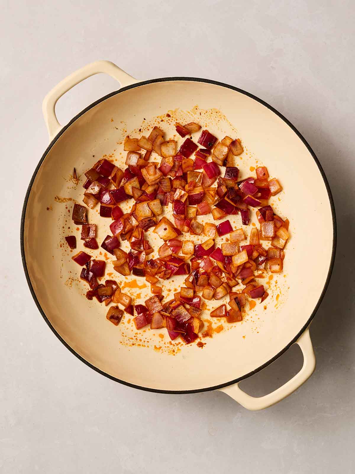 Chopped red onions cooking in a pan.