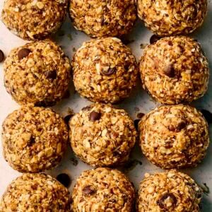 A close up of rows of energy balls with chocolate chips and oats.