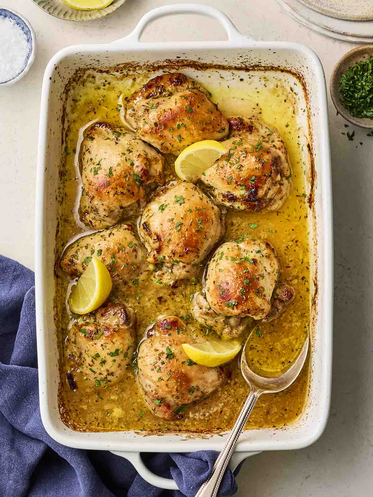 Chicken thighs cooked in an oven dish, with a lemony sauce and herbs.