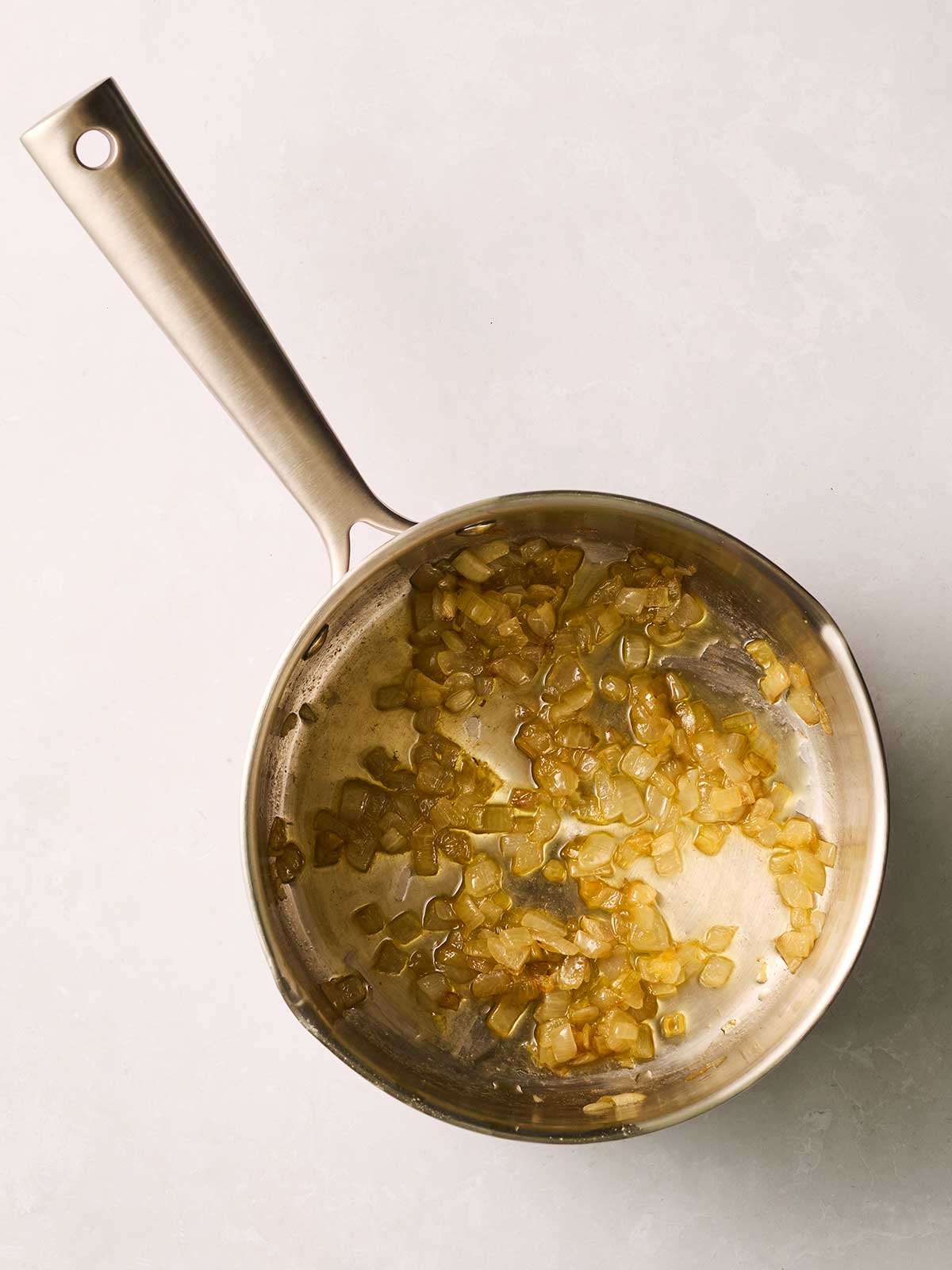 A pan filled with frying chopped onions.