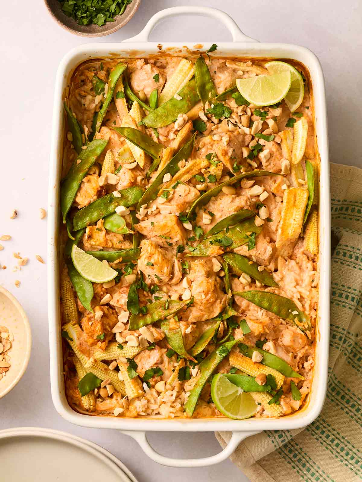 An oven dish with rice, chicken, vegetables in a red Thai sauce.