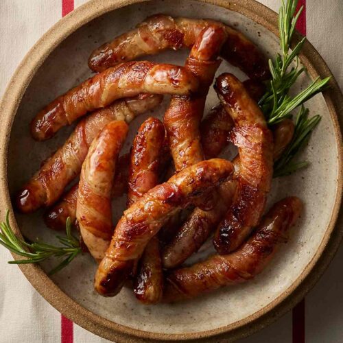 A bowl of sausages wrapped in bacon for a festive season recipe.