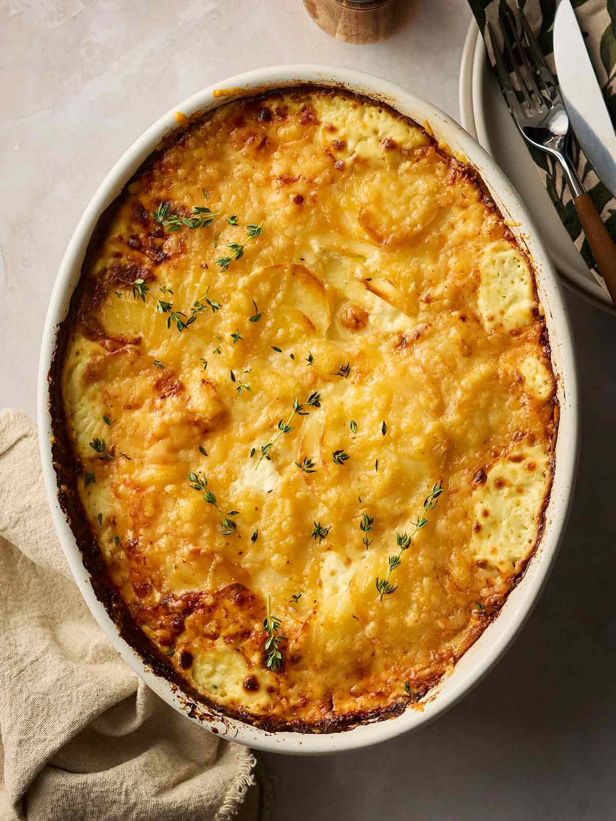 An oven dish filled with cooked Dauphinoise Potatoes, ready to serve.