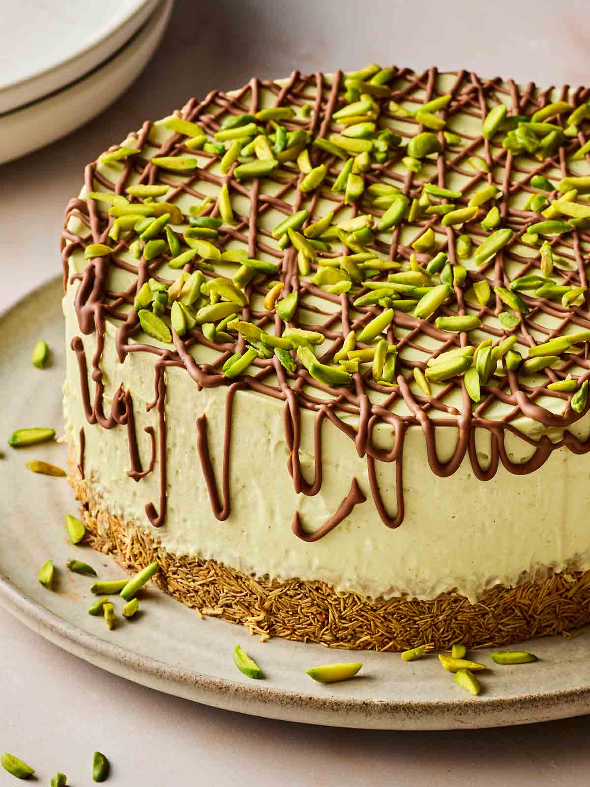 A Dubai Chocolate flavoured cheesecake with pistachios on top on a plate, ready to serve.