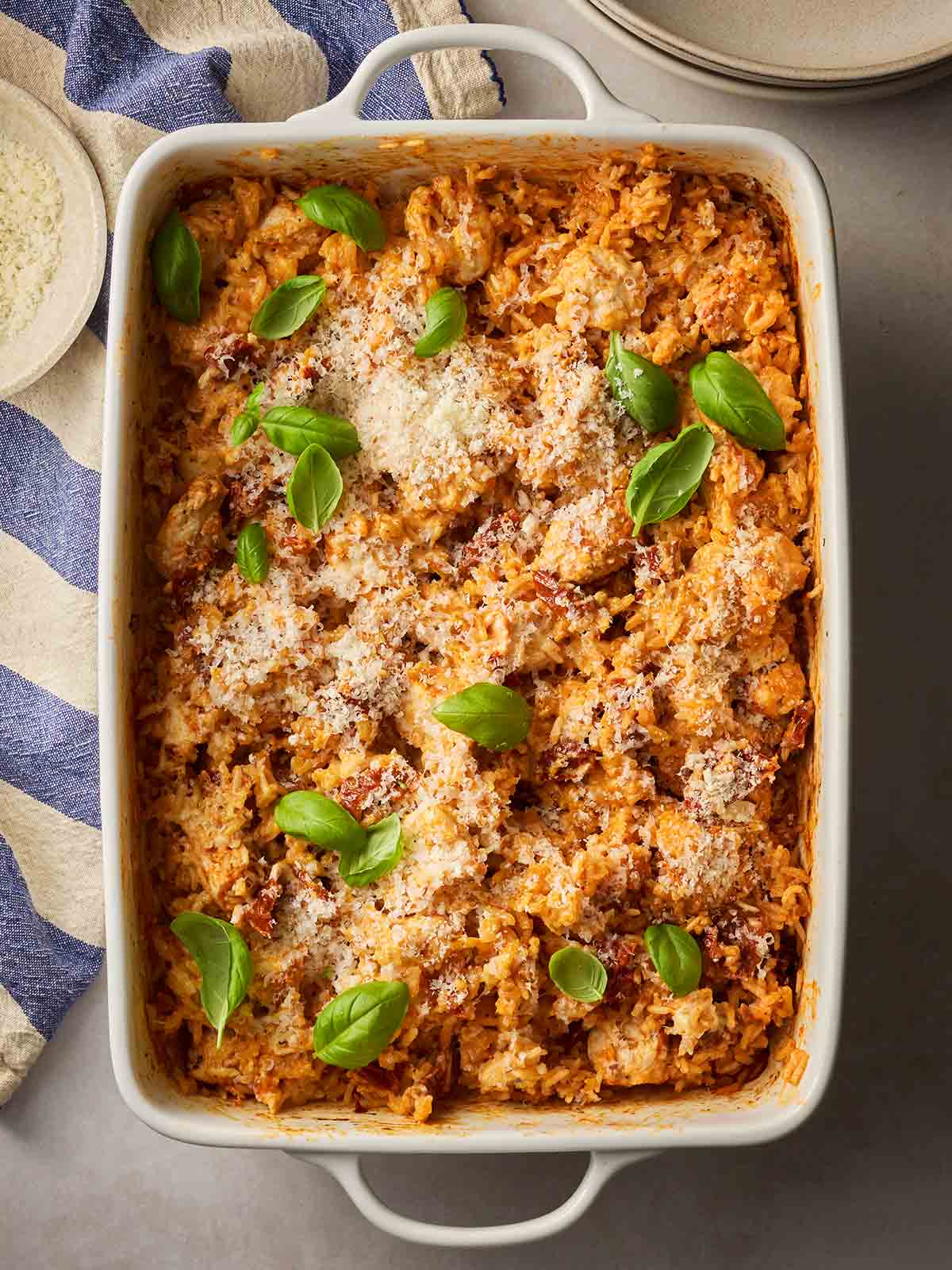 A cooked one pan dish with creamy chicken and rice, with basil over the top, ready to dish up.