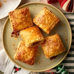A plate of square mince pies made with puff pastry, on a table, ready to eat.
