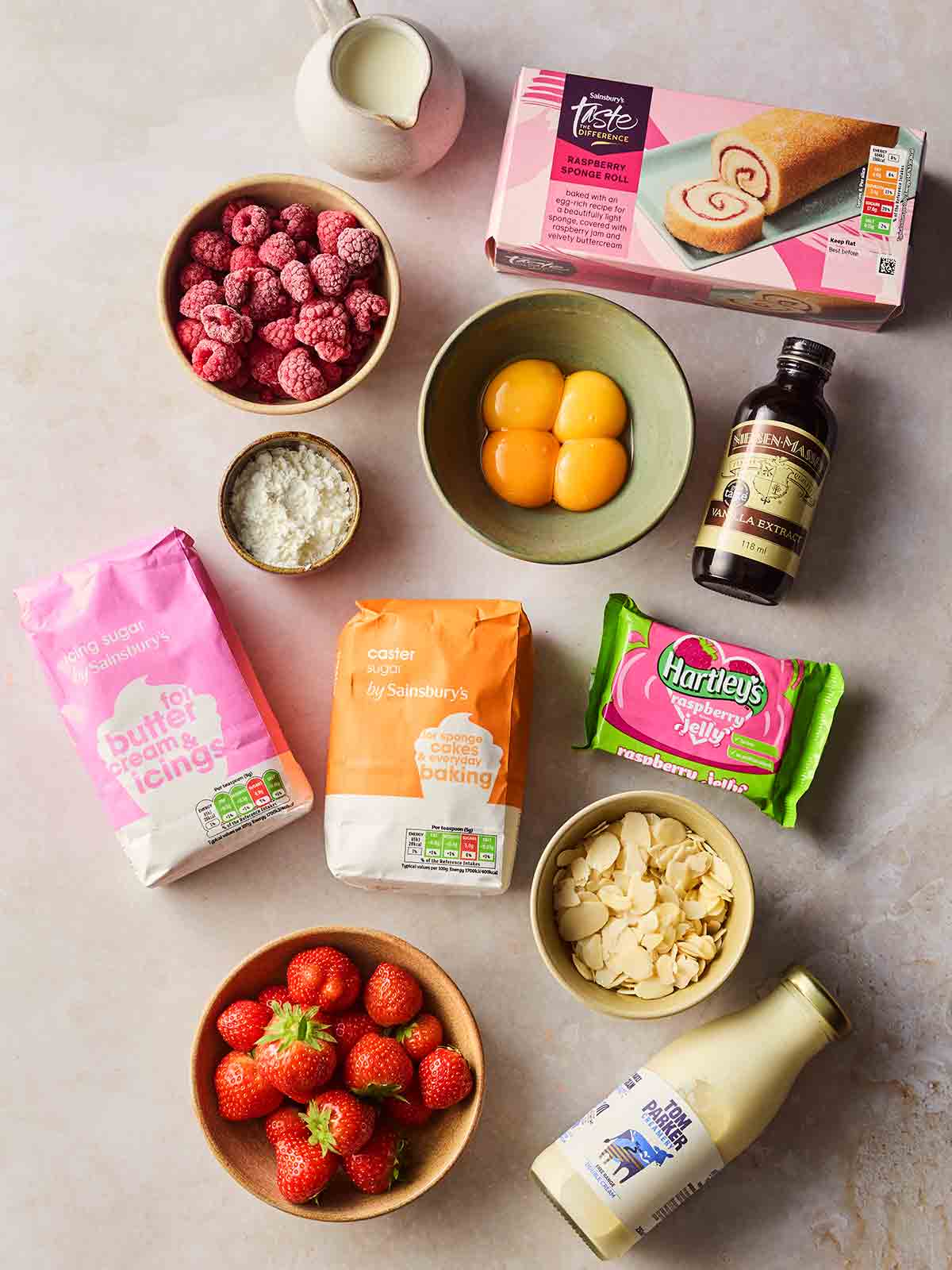 The ingredients or making a classic trifle laid out on a white counter top.