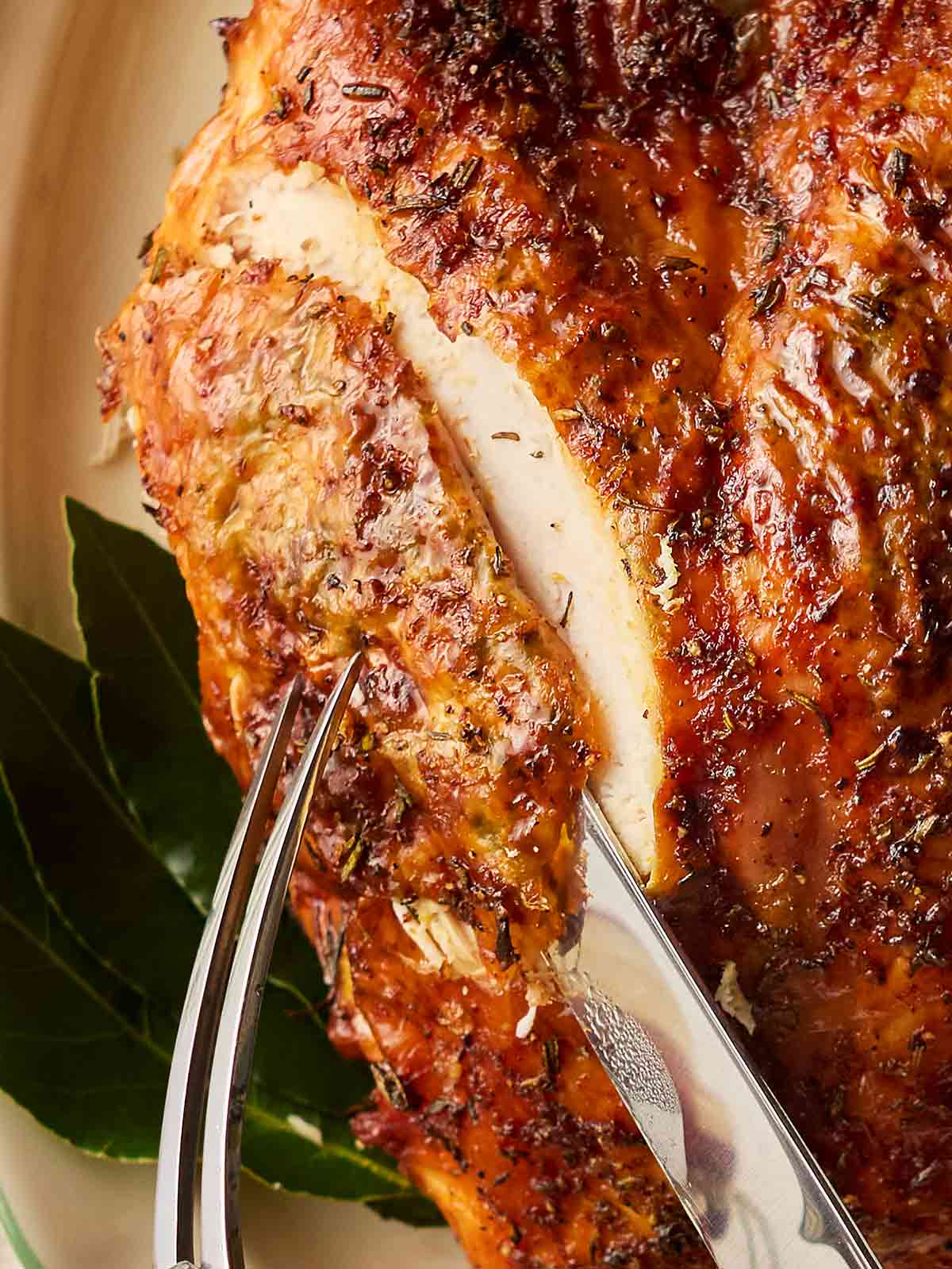 A close up of a turkey being carved with a sharp knife.