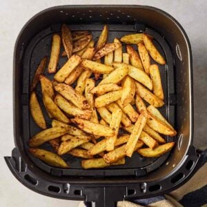 An airfryer pan with cooked homemade chips inside.