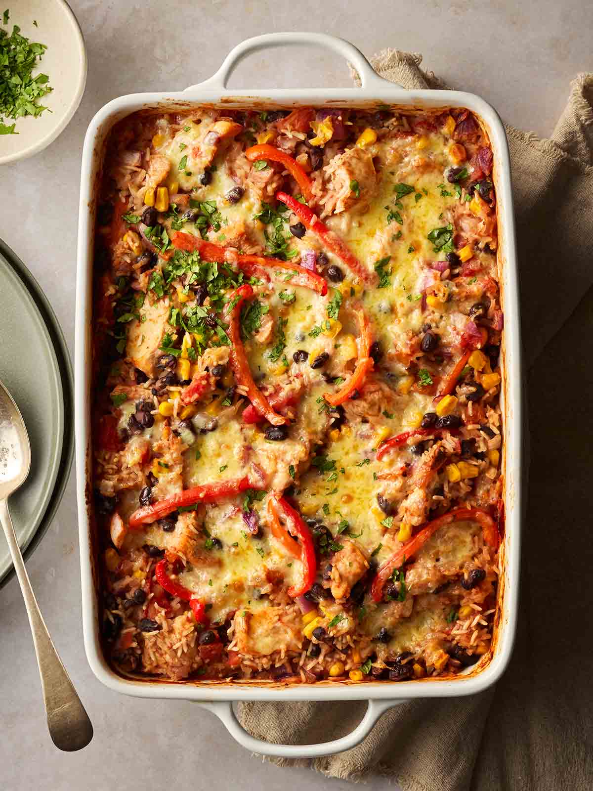 An oven dish with a baked rice dish with chicken and mexican flavours to make a Burrito Dump and Bake recipe.