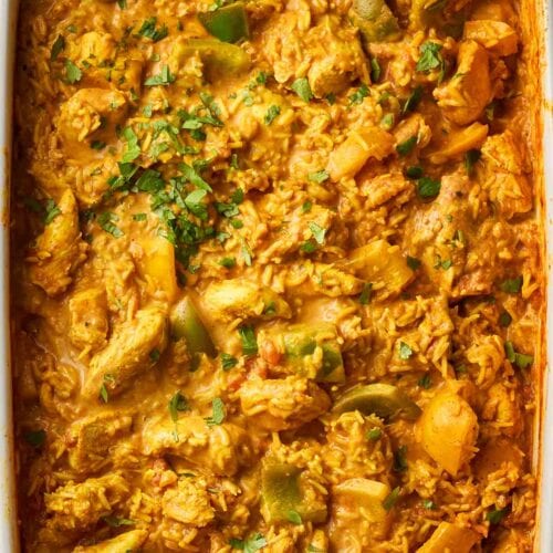 An oven dish with a baked chicken curry and rice dish.