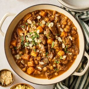 A large casserole dish filled with homemade lamb tagging, with flakes almonds on top.