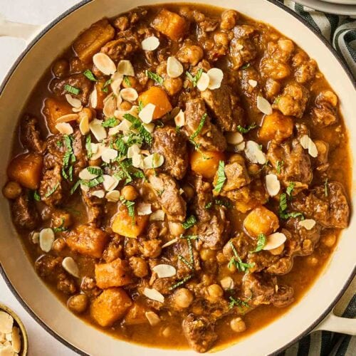 A pot of lamb tagine on a table, ready to be served up.