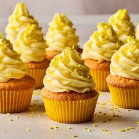 Lemon cupcakes from a side angle, with rows of finshed ones ready to eat.