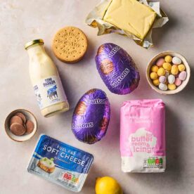 The ingredients for making Easter Egg Cheesecakes laid out on a white surface.