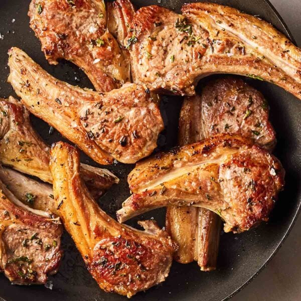 A pile of perfectly cooked Lamb Chops in a pan, ready to serve.