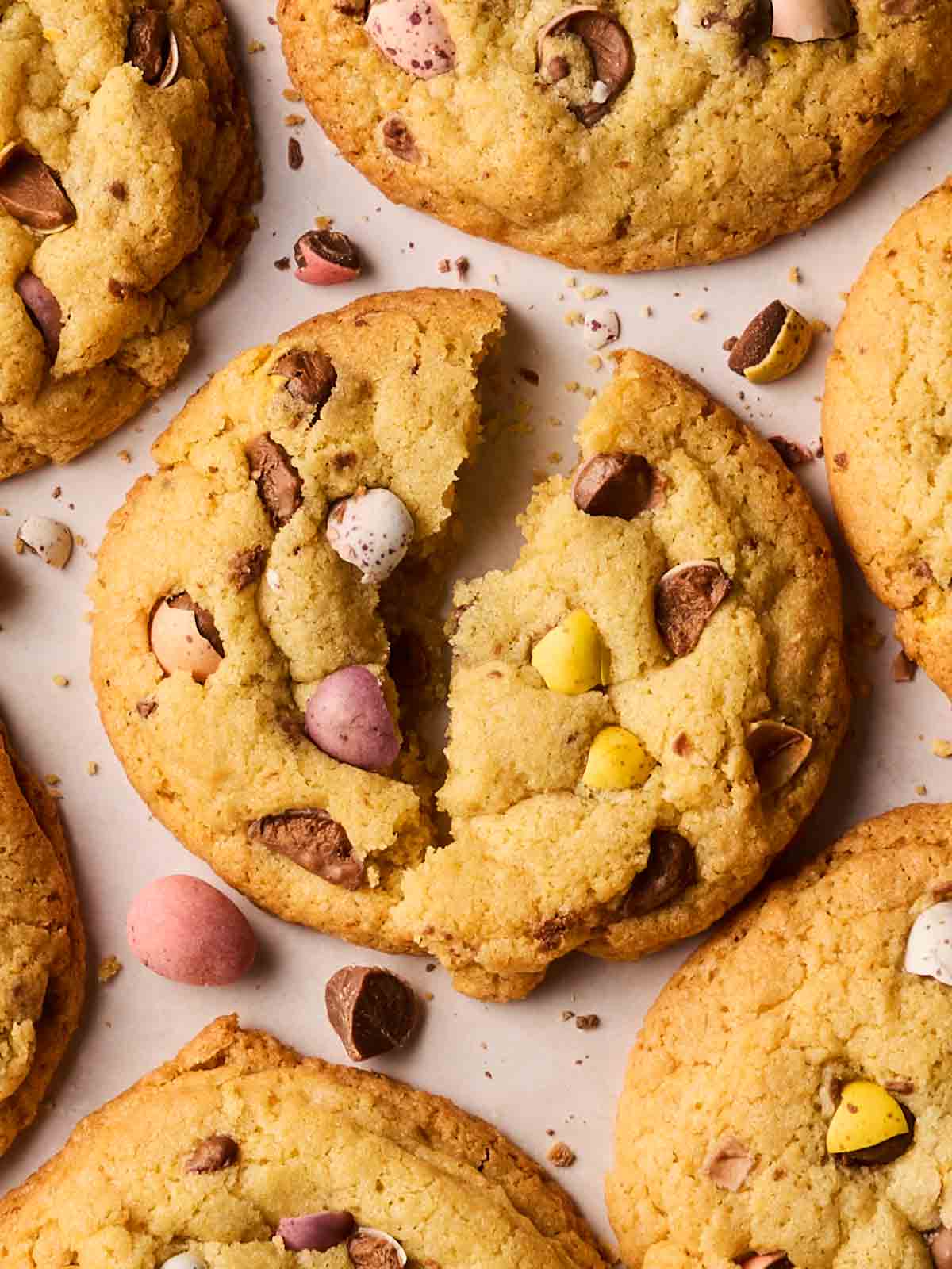 A close up of a mini egg cookie, broken in half on a board.