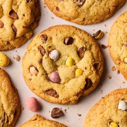 A close up of a batch of freshly baked cookies with mini eggs.