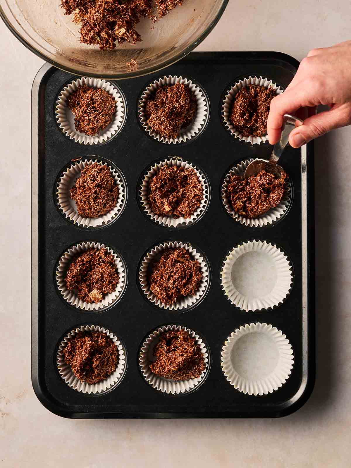 A baking tray with Easter Nests inside the holes, ready to set.