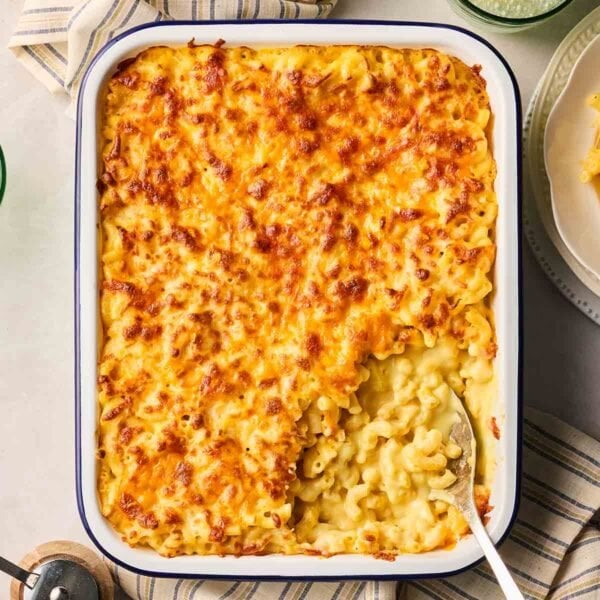 An oven dish filled with Mac and Cheese, about to be served up at the table.