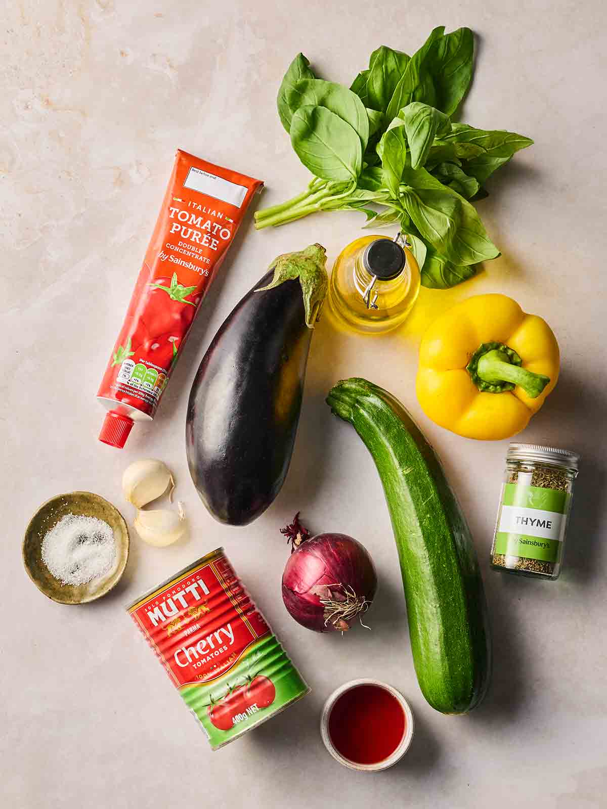 The ingredients for making Ratatouille on a white surface.