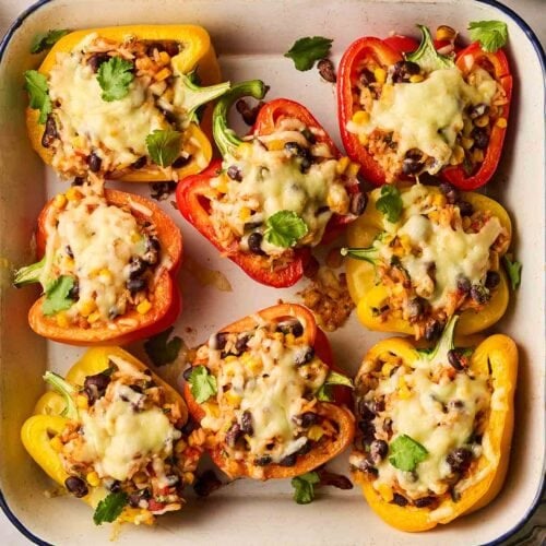 An oven dish with stuffed bell peppers in.