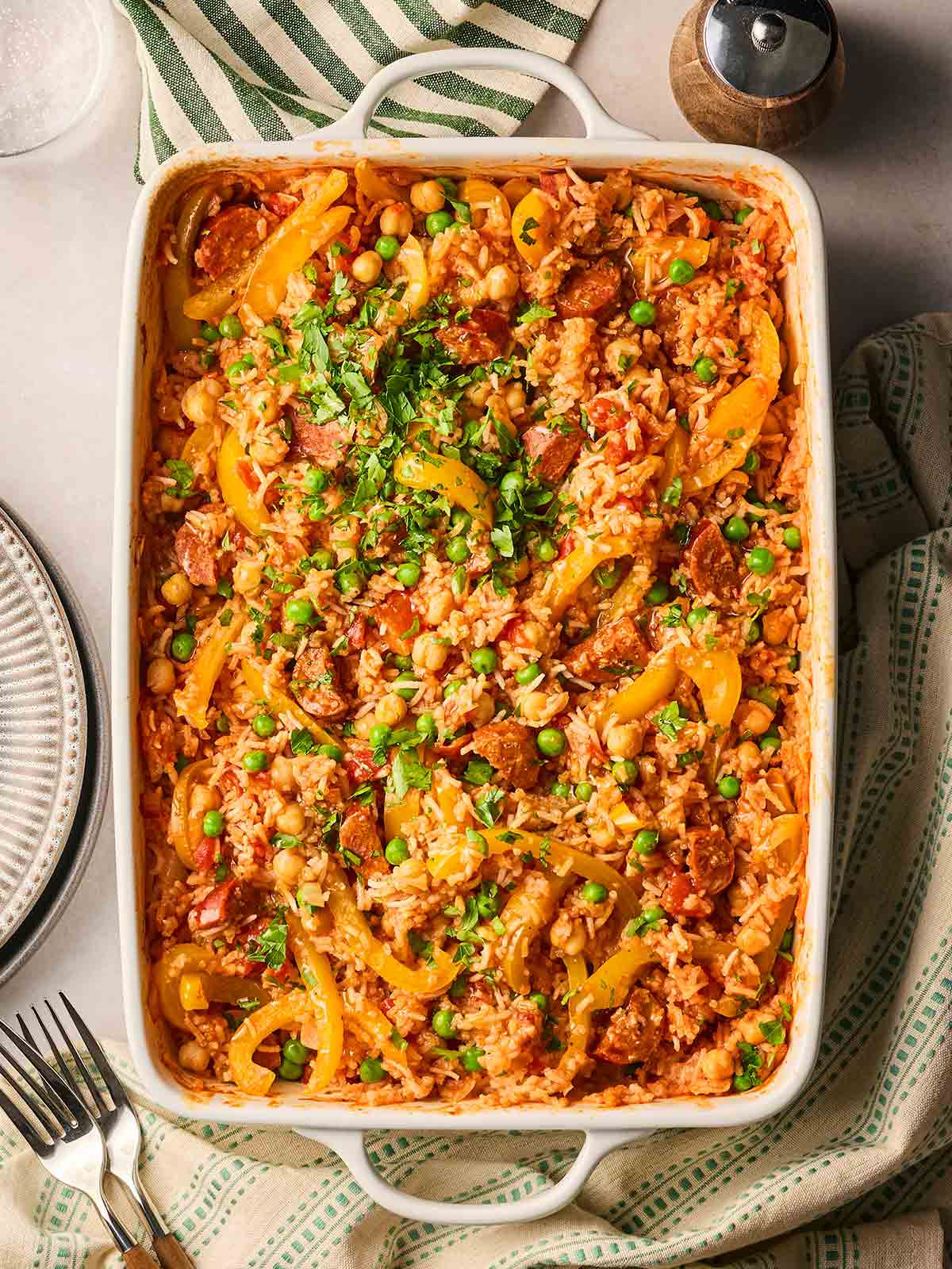 A table with a baked Chorizo and Rice in an oven dish, ready to serve onto plates.