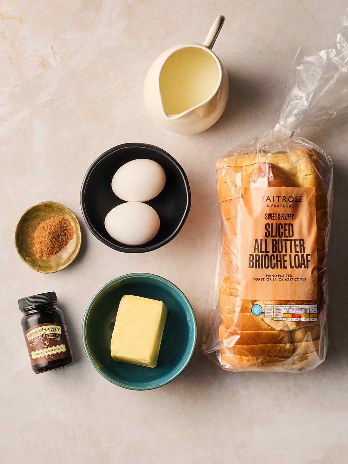 The ingredients for making homemade French Toast laid out on a white surface.